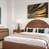 a bedroom with bed lamps and art on the wall
