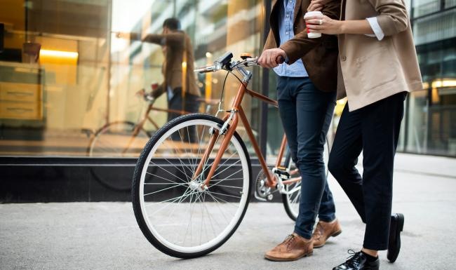 a man and a woman walking with a bicycle